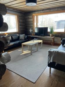 ein Wohnzimmer mit einem Sofa und einem Couchtisch in der Unterkunft Kelotulkku Lodge in Muurame