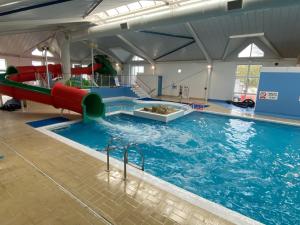 a large indoor swimming pool with a slide in it at 14 Greenwood Thorness Bay in Porchfield