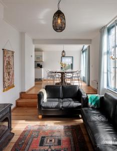 uma sala de estar com um sofá de couro e uma mesa em Koetshuis Buitenplaats Iepenoord em Oostkapelle