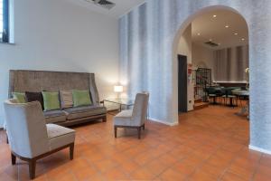 un soggiorno con divano, sedie e tavolo di Hotel Gattapone a Gubbio