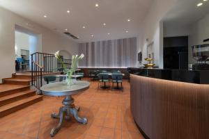 a lobby with a table and chairs and stairs at Hotel Gattapone in Gubbio
