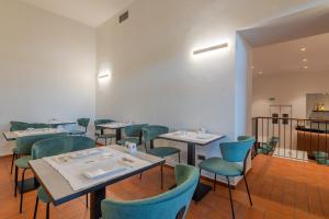 una sala da pranzo con tavoli e sedie blu di Hotel Gattapone a Gubbio