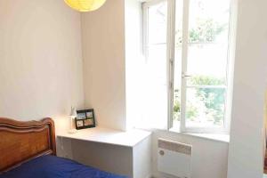 a bedroom with a bed and a window at Logement au calme et en plein cœur ! in Neufchâteau