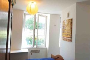 a room with a window and a bed and a lamp at Logement au calme et en plein cœur ! in Neufchâteau