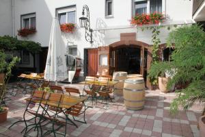 a patio with tables and chairs and an umbrella at Gasthof Krancher in Rüdesheim am Rhein