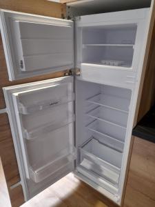 an empty refrigerator with its door open in a kitchen at Gwenaelle et Cyrille in Abbeville