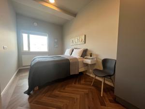 - une chambre avec un lit, une chaise et une fenêtre dans l'établissement Iceland SJF Apartments - 201, à Reykjavik