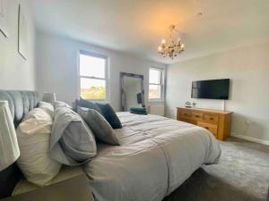 1 dormitorio con 1 cama grande y TV en 3bed house with Parking short walk to Bath centre en Bath