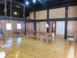 Cette grande chambre comprend une table et des chaises. dans l'établissement 民泊くま - 絵画と音楽の宿, à Inawashiro