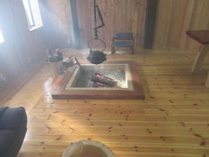 chimenea en una habitación con suelo de madera en 民泊くま - 絵画と音楽の宿 en Inawashiro