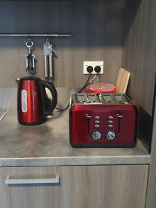 a red appliance sitting on a counter next to a tea kettle at The Red Shed in Matamata
