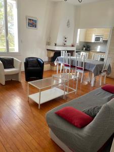 salon z kanapą, stołem i krzesłami w obiekcie Duplex 130m2 dans un mas entouré de vergers - piscine w mieście Saint-Féliu-dʼAvall