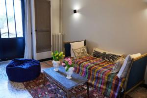 a living room with a couch and a table with flowers at Lofts L'Écluse, parking gratuit in Saint-Valéry-sur-Somme