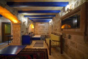 a room with a bed and a tv on a wall at Alaturca House in Göreme
