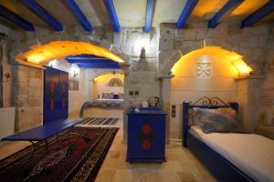 a bedroom with two beds and a stone wall at Alaturca House in Göreme