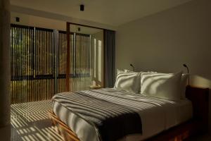 a bedroom with a large bed with white pillows at Innit Lombok in Ekas