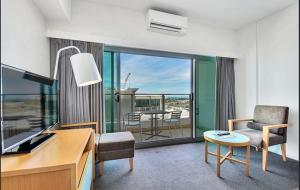 um quarto com uma secretária, uma cadeira e uma mesa em Darwin Harbour Suite em Darwin