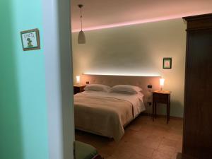 a bedroom with a bed with a pink light above it at Tenuta Monaci La Murra in Carmiano