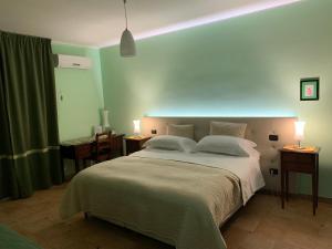 a bedroom with a large bed with two lamps on tables at Tenuta Monaci La Murra in Carmiano