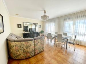- un salon avec un canapé et une table avec des chaises dans l'établissement casa patricia, à Pontevedra