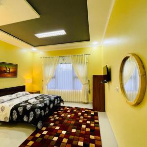 1 dormitorio con cama y espejo en Pelataran Seroja Villas, en Wonosobo