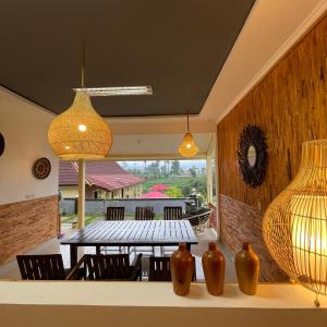 comedor con mesa y algunos jarrones en Pelataran Seroja Villas, en Wonosobo