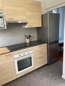 kuchnia z kuchenką i lodówką w obiekcie Duplex 130m2 dans un mas entouré de vergers - piscine w mieście Saint-Féliu-dʼAvall