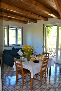 uma sala de jantar com uma mesa com flores em Casale Dionisia a Castellabate, Appartamento Fico em Santa Maria di Castellabate