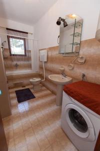 uma casa de banho com uma máquina de lavar roupa e um lavatório em Apartments Vita em Novi Vinodolski