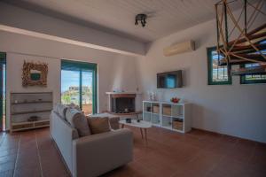 a living room with a couch and a fireplace at Villa Calliope Lardos in Lardos