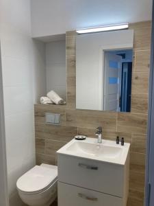 a bathroom with a sink and a toilet and a mirror at Tabago Studio 7 in Kędzierzyn-Koźle