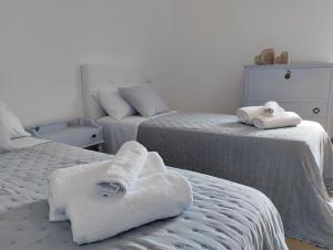 two beds with towels on them in a bedroom at Domus terme romane in Cividale del Friuli