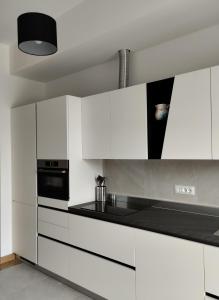 a kitchen with white cabinets and a stove top oven at Domus terme romane in Cividale del Friuli