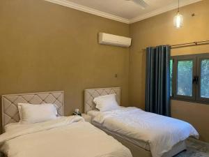 Duas camas sentadas uma ao lado da outra num quarto em Rose Guesthouse em Al ‘Aqar