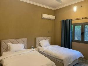 two beds sitting next to each other in a bedroom at Rose Guesthouse in Al ‘Aqar