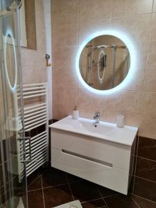 a bathroom with a white sink and a mirror at Apartman Vinyl - self chek-in in Osijek