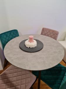 a table with a hat and a pink candle on it at Apartman Vinyl - self chek-in in Osijek