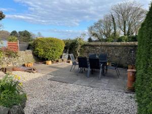 a patio with chairs and a table in a garden at 40 Main Street in Burntisland