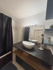 La salle de bains est pourvue d'un lavabo et d'un grand miroir. dans l'établissement Loft ravissant avec jacuzzi et parc, à Orange