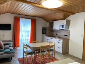 een keuken en eetkamer met een tafel en stoelen bij Hotel Seerose Wolfgangsee in St. Wolfgang