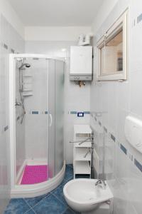 uma casa de banho com um chuveiro e um lavatório. em Residence La Pigna em Rosolina Mare