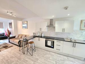 a kitchen and living room with a couch and a table at Hawkins Town House Near City Ctr and all Amenities in Liverpool