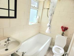 La salle de bains est pourvue d'une baignoire, de toilettes et d'un lavabo. dans l'établissement Hawkins Town House Near City Ctr and all Amenities, à Liverpool