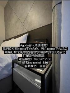 um quarto com uma cama e uma mesa de cabeceira com escrita em 北緯23點5度民宿-車位可預訂 em Hualien City