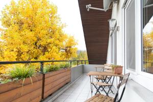 a balcony with a table and chairs and a tree at Moderne Ferienwohnung in der Natur - 3 Schlafzimmer & 1,5 Bäder in Markdorf