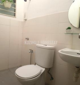 y baño con aseo y lavamanos. en Kozimuji en Seri Kembangan