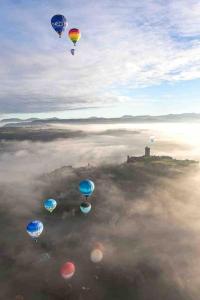 un groupe de ballons volant dans le ciel au-dessus des nuages dans l'établissement Maison atypique - centre historique - Puy en Velay, au Puy-en-Velay