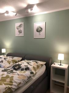 1 dormitorio con 1 cama y 2 cuadros en la pared en Ferienwohnung Bergzeit mit Sauna und Pool en Sankt Englmar