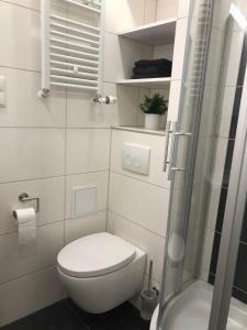 y baño blanco con aseo y ducha. en Ferienwohnung Bergzeit mit Sauna und Pool, en Sankt Englmar