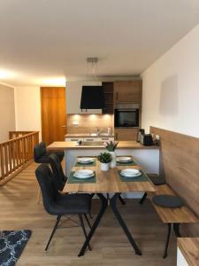 a kitchen and living room with a table and chairs at Ferienwohnung Bergzeit mit Sauna und Pool in Sankt Englmar +23 photos